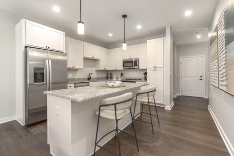 a kitchen with white cabinets and a marble counter top